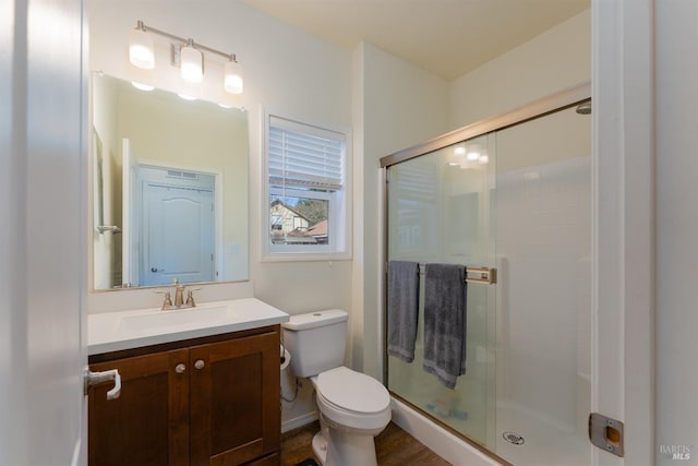 full bath featuring vanity, toilet, and a shower stall
