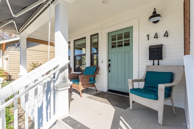 view of exterior entry featuring covered porch
