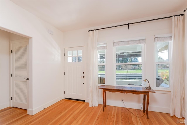 foyer entrance featuring baseboards and light wood-type flooring