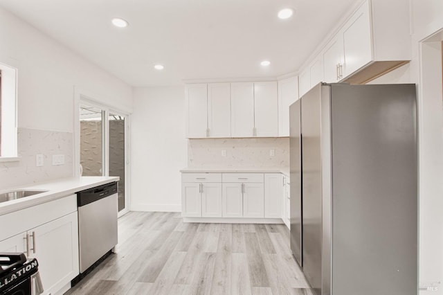 308 Central Ave, Vallejo, CA 94590 - kitchen featuring light wood-type flooring, light countertops, white cabinets, appliances with stainless steel finishes, and backsplash