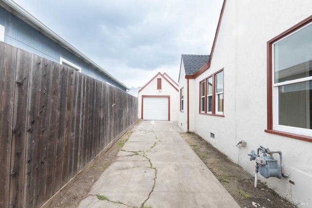 308 Central Ave, Vallejo, CA 94590 - view of side of property with fence, stucco siding, a shingled roof, concrete driveway, and an outbuilding