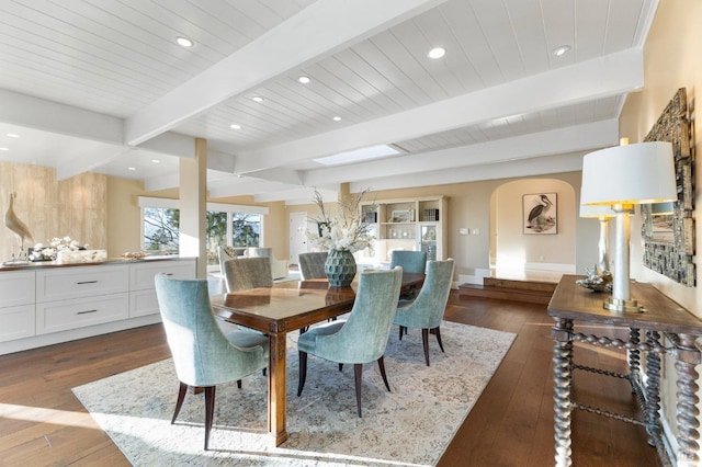 dining space featuring dark wood-style floors, arched walkways, beam ceiling, and recessed lighting
