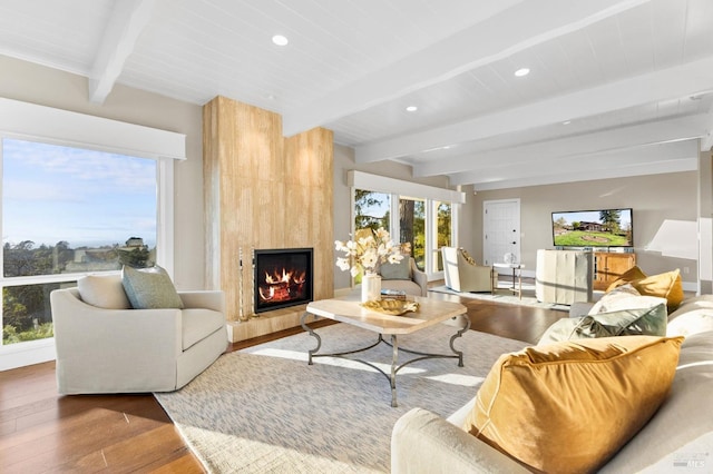 living area featuring a fireplace, wood finished floors, recessed lighting, and beam ceiling