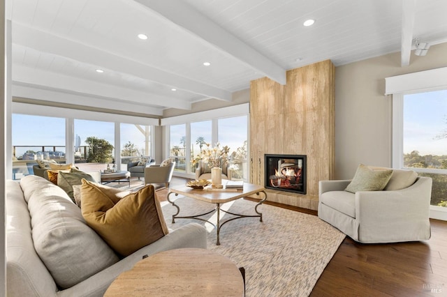 living room with recessed lighting, beam ceiling, a multi sided fireplace, and wood finished floors