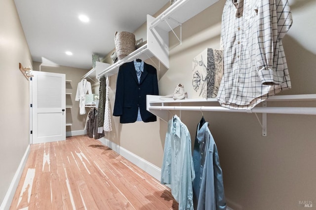 walk in closet with wood finished floors