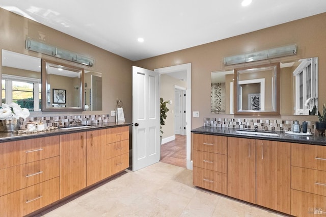 full bathroom with backsplash, a sink, and two vanities