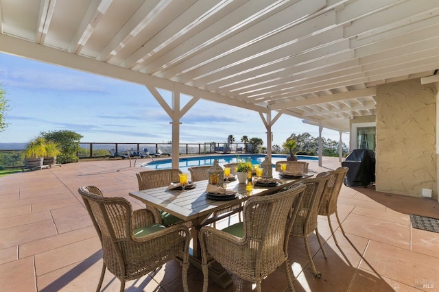 view of patio featuring a community pool, outdoor dining area, and a grill