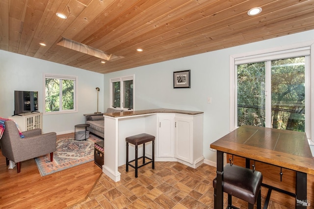 kitchen with white cabinetry, recessed lighting, baseboards, wood ceiling, and a peninsula