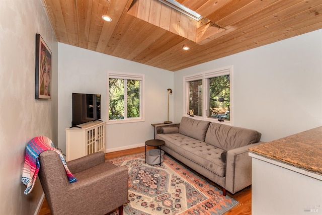 living area with wood finished floors, wooden ceiling, a skylight, and recessed lighting
