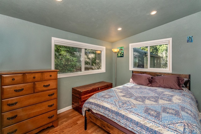 bedroom featuring a textured ceiling, baseboards, recessed lighting, lofted ceiling, and light wood-style floors