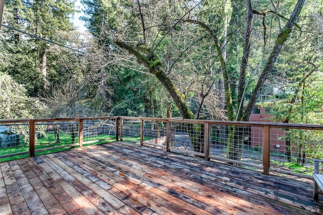 wooden terrace featuring a wooded view