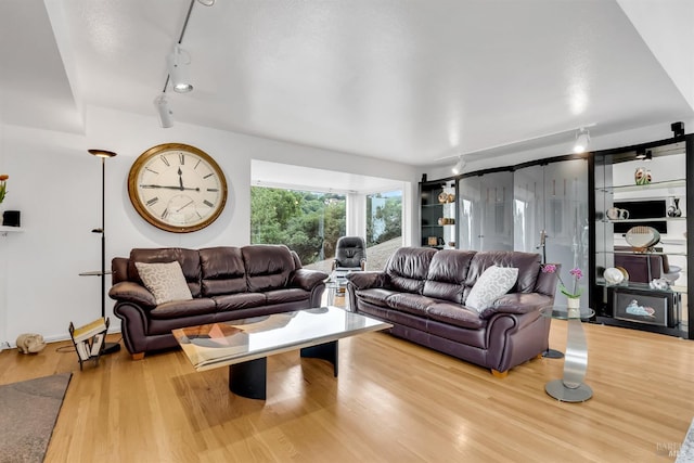 living room with track lighting and wood finished floors