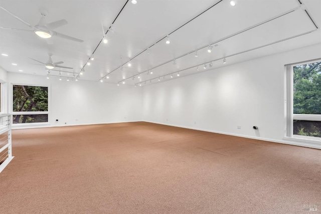carpeted spare room featuring baseboards and a ceiling fan