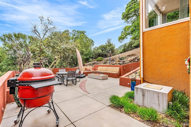 view of patio / terrace with a grill, an outdoor living space with a fire pit, and outdoor dining space