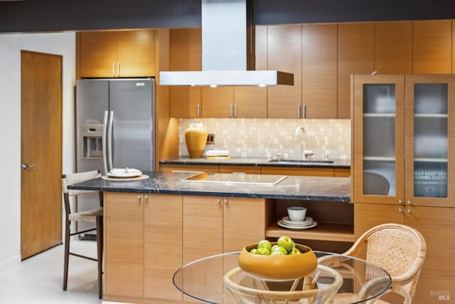 kitchen with island exhaust hood, tasteful backsplash, a sink, black electric stovetop, and a kitchen breakfast bar