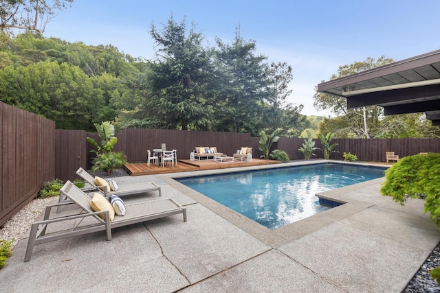 view of pool with a fenced backyard, a fenced in pool, a patio area, and a wooden deck