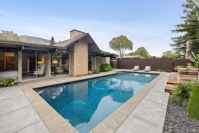view of swimming pool with fence, a fenced in pool, and a patio area