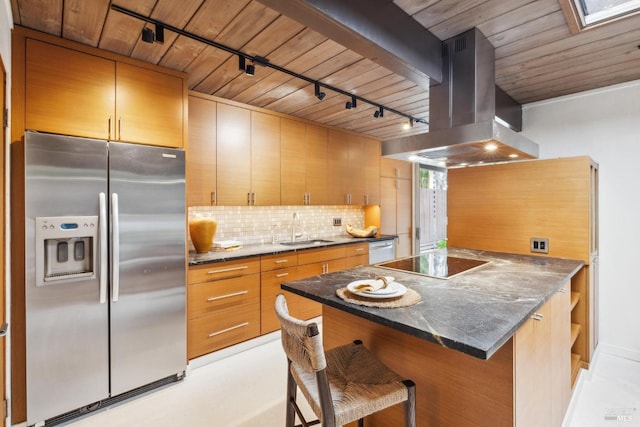 kitchen featuring stainless steel refrigerator with ice dispenser, island range hood, black electric stovetop, decorative backsplash, and a sink