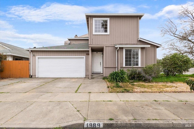 traditional home with concrete driveway, a chimney, fence, and an attached garage