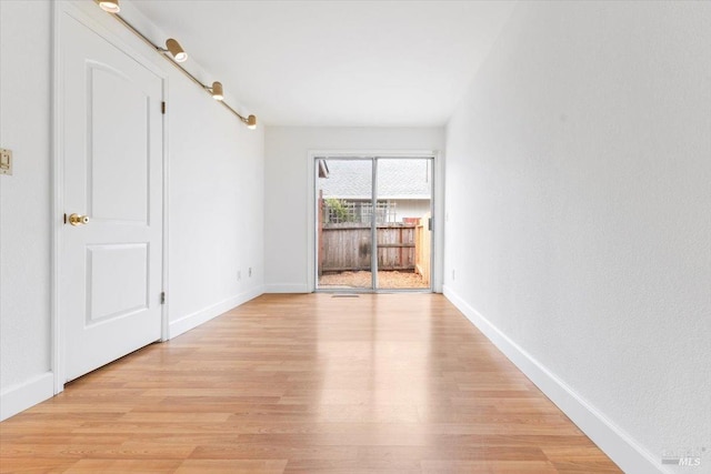 spare room with light wood-style flooring and baseboards