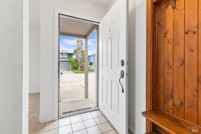 entryway featuring light colored carpet and light tile patterned floors