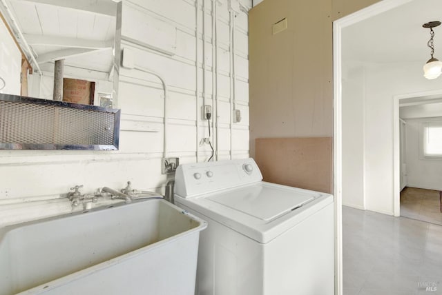 clothes washing area with washer / clothes dryer, a sink, and laundry area