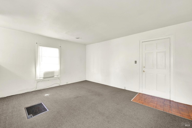 empty room with visible vents and carpet floors