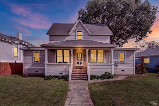view of front of property featuring covered porch, crawl space, fence, and a lawn