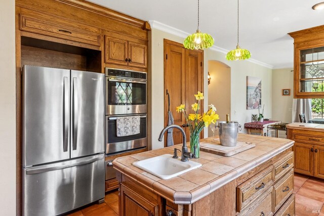 11900 Hwy 116, Guerneville, CA 95446 - kitchen with brown cabinetry, ornamental molding, tile counters, a sink, and stainless steel appliances