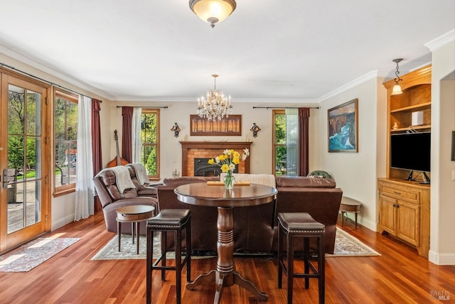 11900 Hwy 116, Guerneville, CA 95446 - dining room with a brick fireplace, an inviting chandelier, a healthy amount of sunlight, and wood finished floors
