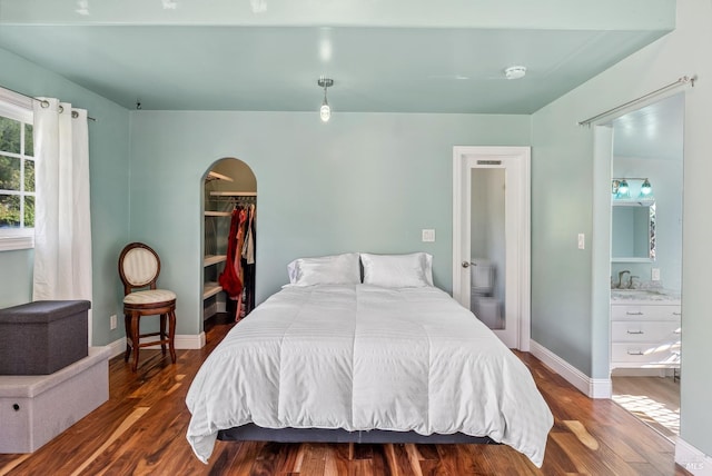 11900 Hwy 116, Guerneville, CA 95446 - bedroom with arched walkways, baseboards, wood finished floors, and a walk in closet