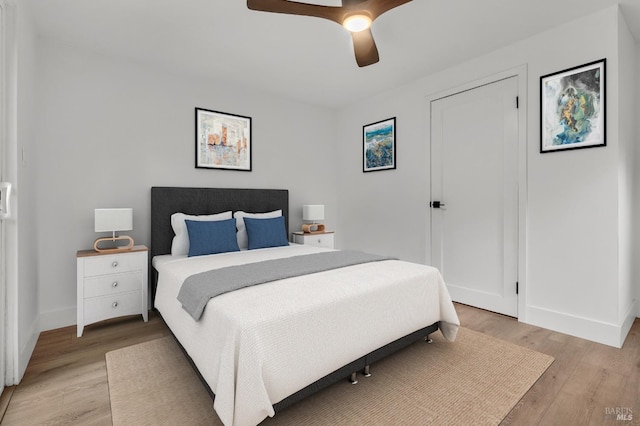 bedroom featuring a ceiling fan, baseboards, and light wood-style floors