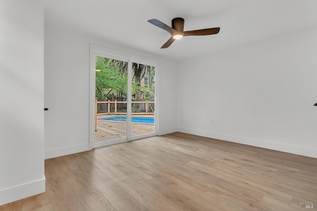 empty room featuring baseboards, light wood-style floors, and ceiling fan