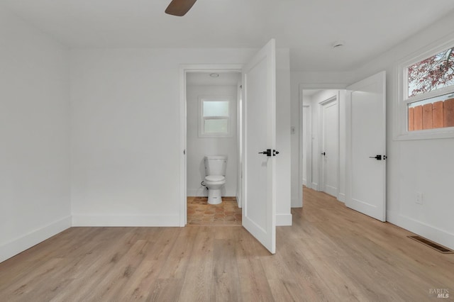 unfurnished bedroom featuring light wood-type flooring, baseboards, ceiling fan, and visible vents