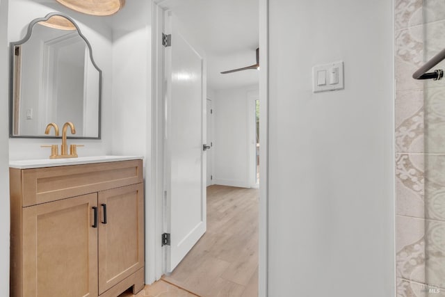 bathroom featuring vanity, baseboards, and wood finished floors