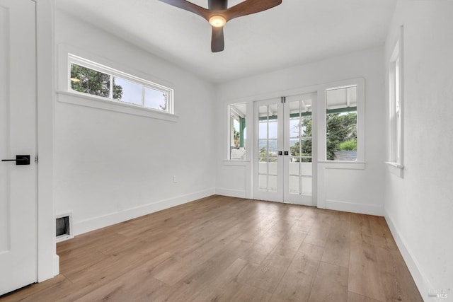 spare room featuring a wealth of natural light, visible vents, french doors, and wood finished floors