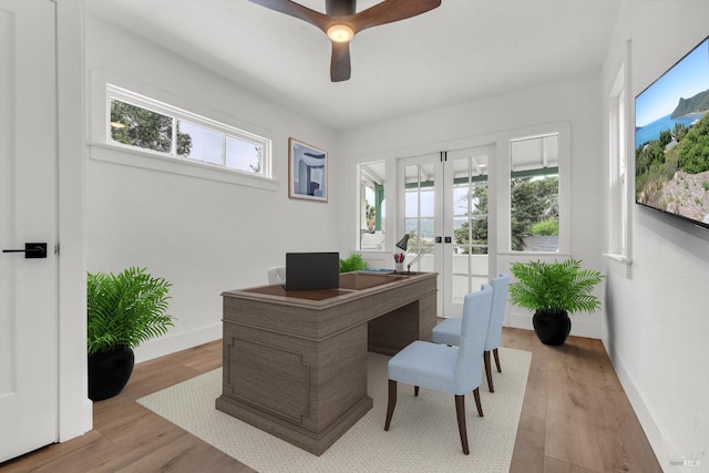 home office featuring baseboards, ceiling fan, light wood-style flooring, and french doors