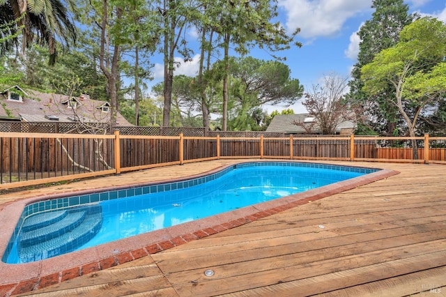 view of pool with a fenced in pool, a fenced backyard, and a wooden deck