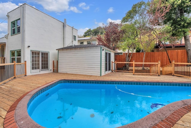 view of pool with a fenced in pool, fence, and a wooden deck