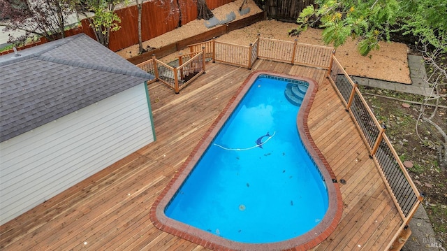view of swimming pool featuring a fenced backyard and a deck