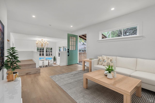 living room with an inviting chandelier, recessed lighting, and wood finished floors