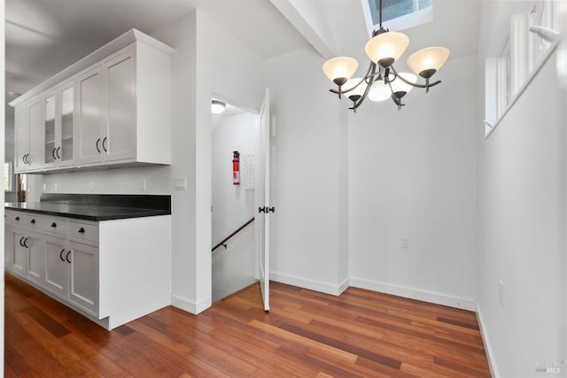 162 Wolfe Grade, Kentfield, CA 94904 - unfurnished dining area with a chandelier, dark wood-type flooring, baseboards, and healthy amount of natural light