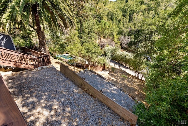 162 Wolfe Grade, Kentfield, CA 94904 - view of yard featuring a wooden deck, a garden, and a wooded view
