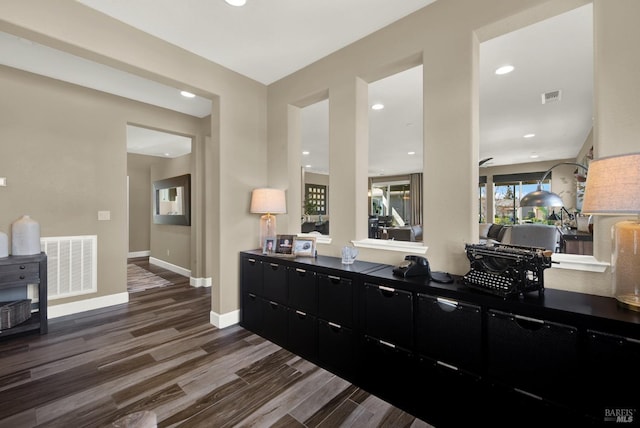 interior space with dark wood-type flooring, visible vents, baseboards, and recessed lighting