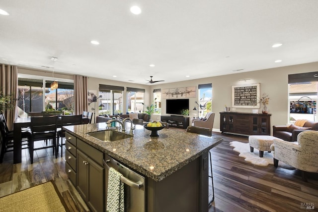 kitchen with stainless steel dishwasher, open floor plan, a sink, and recessed lighting