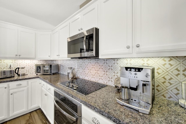 kitchen featuring white cabinets, backsplash, and appliances with stainless steel finishes