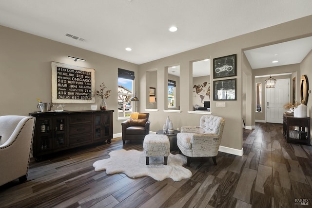 living area featuring baseboards, visible vents, recessed lighting, an inviting chandelier, and wood finished floors