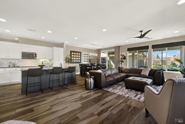 living area with plenty of natural light, visible vents, recessed lighting, and dark wood-type flooring
