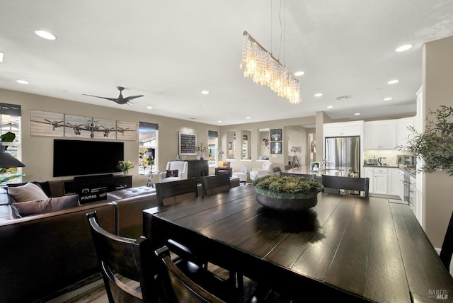 dining space with recessed lighting, wood finished floors, visible vents, and ceiling fan with notable chandelier