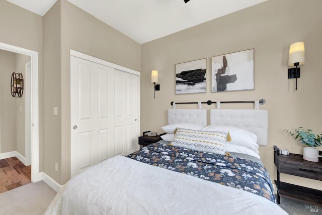 carpeted bedroom featuring a closet and baseboards